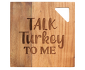 The Maple 12 x 12" Acacia Modern Geo Square cutting board features "Talk Turkey To Me" engraved and a triangular cut-out, perfect as a cheese or charcuterie serving board for gatherings.