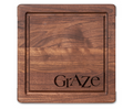 The Maple 12 x 12" Walnut Square Board | Graze features a groove around the edge and "GrAZe" engraved in the corner, making it perfect as a stylish charcuterie board.