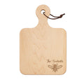 The Maple 12" x 8" Maple Wood Board features a handle, leather loop, and “The Seehoffs” engraved above a honeybee illustration—personalized and perfect as a charcuterie board for any gathering.