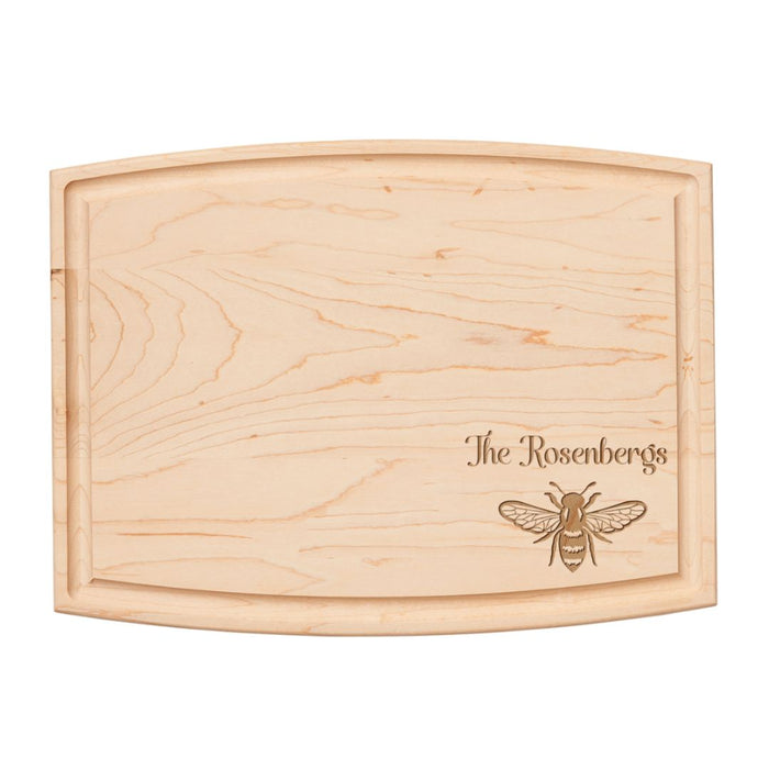 The Maple 12" x 9" Arched Maple Board features natural wood grain and an engraved honeybee illustration with “The Rosenbergs” in elegant script on the lower right corner. Personalization available.