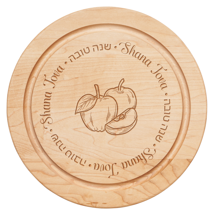 The 12x12" Maple Round Board - Shana Tova Round Apples by Maple features two apples and a center slice, with "Shana Tova" in English and Hebrew—ideal for celebrating Rosh Hashanah and wishing a sweet new year.
