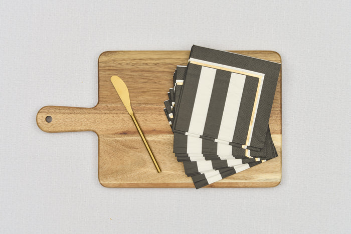 The Sophistiplate 14" x 8" Board Gift Kit: Cordoba features a wooden board, gold butter knife, and black and white striped napkins with gold edges, all neatly displayed on a light gray surface.