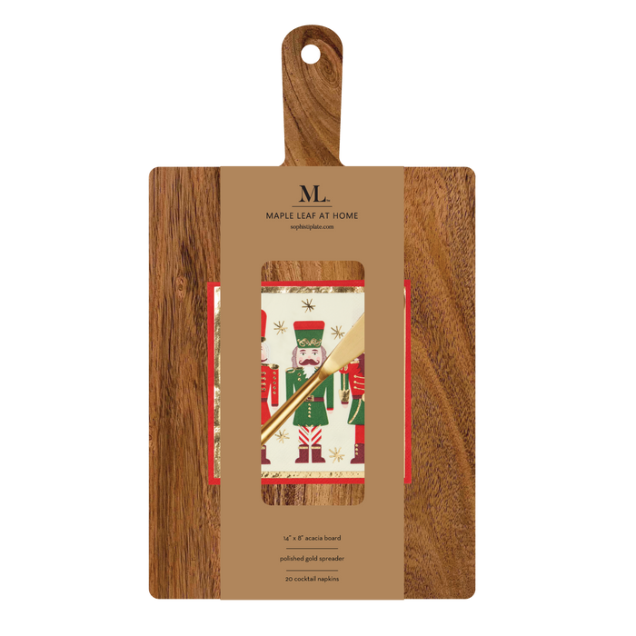 The Sophistiplate 14" x 8" Board Gift Kit: Nutcracker Christmas includes an acacia wood charcuterie board, a gold spreader, and festive nutcracker napkins, all packaged with a brown Maple Leaf at Home label.