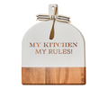 The Maple 15"x12" Acacia Bevel Board in White with Gold Spreader features “My Kitchen My Rules,” a striped bow, and is ideal as a cheese board or kitchen accent with its engraved acacia wood and stylish two-tone design.