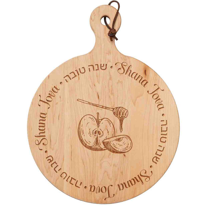 The Maple 16x12" Artisan Round Board, engraved with “Shana Tova” in English and Hebrew and featuring apple slices and a honey dipper, is a perfect centerpiece for celebrating Rosh Hashanah.