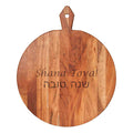 The Maple 20x16" Acacia Heirloom Board Round – Shana Tova features a handle and “Shana Tova!” engraved in English and Hebrew—ideal for festive Rosh Hashanah gatherings.