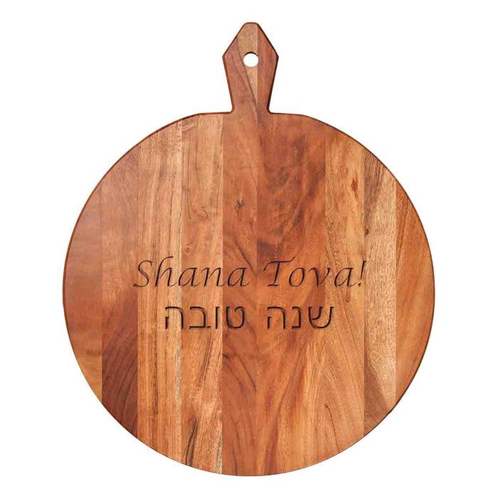 The Maple 20x16" Acacia Heirloom Board Round – Shana Tova features a handle and “Shana Tova!” engraved in English and Hebrew—ideal for festive Rosh Hashanah gatherings.