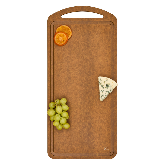 The Maple 22" x 10" Natural Wood Composite Chef Board, which is heat-resistant and dishwasher safe, displays green grapes, two orange slices, and a wedge of blue cheese spaced apart on its surface with a handle.