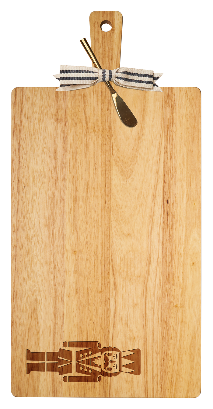 The Maple 24" x 12" Rubber Wood Thick Handle Board with Gold Spreader features a Nutcracker design, striped ribbon accent, and makes a unique housewarming gift.