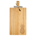 The Maple 24" x 12" Rubber Wood Thick Handle Cutting Board | Pineapple features a striped bow, a small cheese knife, and an engraved pineapple in the corner, blending style and function for your charcuterie needs.