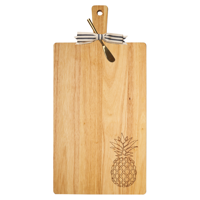 The Maple 24" x 12" Rubber Wood Thick Handle Cutting Board | Pineapple features a striped bow, a small cheese knife, and an engraved pineapple in the corner, blending style and function for your charcuterie needs.