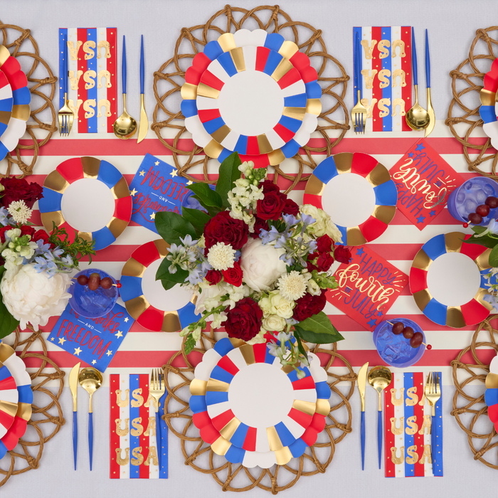 Elevate your celebration with the Sophistiplate Modern Patriotic Table Setting, featuring red, white, and blue designer plates, striped napkins, gold cutlery, and a festive runner—perfect for any patriotic gathering.
