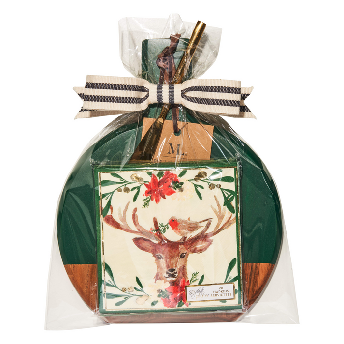 The Maple 9.75" x 8" Board Gift Kit: Christmas Forest features a green and acacia wood charcuterie board, a festive napkin with deer and red flowers, all wrapped in clear plastic with a ribbon and small tag—perfect for gifting.