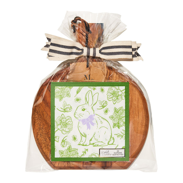 The Sophistiplate 9.75" x 8" Board Gift Kit w/o spreader: Easter Toile features an acacia wood board with a handle, wrapped in clear plastic and tied with a striped ribbon, plus a green card showing a white bunny with a purple bow amid flowers and leaves.