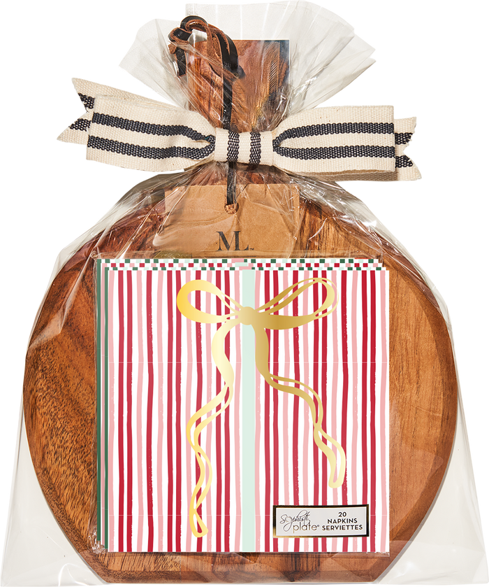 A 9.75″ x 8″ Sophistiplate Board Gift Kit—Tis the Season—is wrapped in clear plastic with a striped bow and features acacia wood, holding red and white striped cocktail napkins with a gold ribbon design.