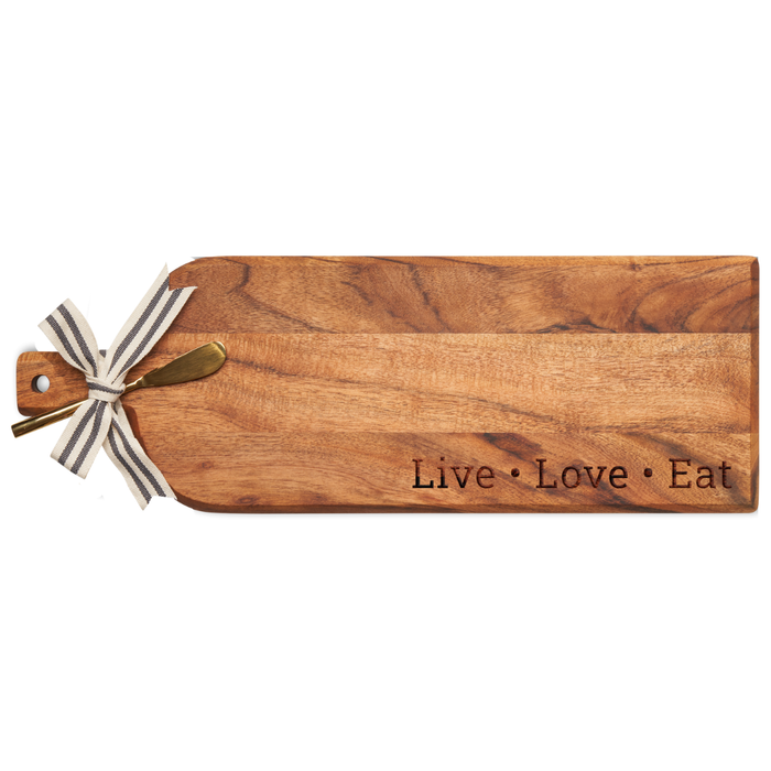 The Maple Acacia Bevel Board Long (20 x 7") features “Live • Love • Eat” engraving, a gold spreader, and a black-and-white striped ribbon—perfect for stylish and functional cheese or charcuterie presentations.