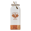 The Maple Acacia Bevel Board Long White (20 x 7") features a white and acacia finish, ribbon-tied handle, crossed paddles with "DESIGNATED DINKER," and includes a gold spreader—ideal as a charcuterie serving board.