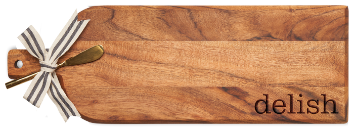 The Maple Acacia Bevel Board (20 x 7") features "Delish" engraving and comes with a gold spreader knife tied with a striped ribbon, perfect for serving charcuterie.