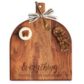The Maple Acacia Bevel Board (15x12"), engraved with "Everything Tastes Better On A Board," includes a cheese wheel, fruit and nut crackers, a gold spreader knife, and a striped ribbon bow on the handle.