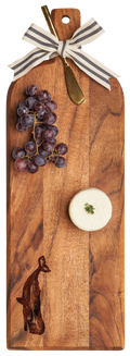 The Maple Acacia Bevel Board w/ Ribbon & Gold Spreader Knife | Whale | 20 x 7" is a wooden serving tray decorated with a ribbon, gold knife, red grapes, and herb-soft cheese on top. Features an engraved whale design.