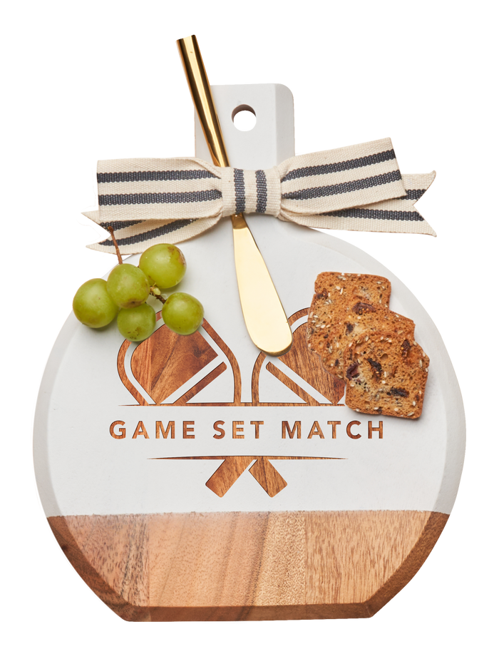 The Maple Acacia Bevel Board White (9.75 x 8") features “GAME SET MATCH” above crossed racquets, striped ribbon accent, and a gold spreader knife—perfect for serving cheese, crackers, and grapes in style.