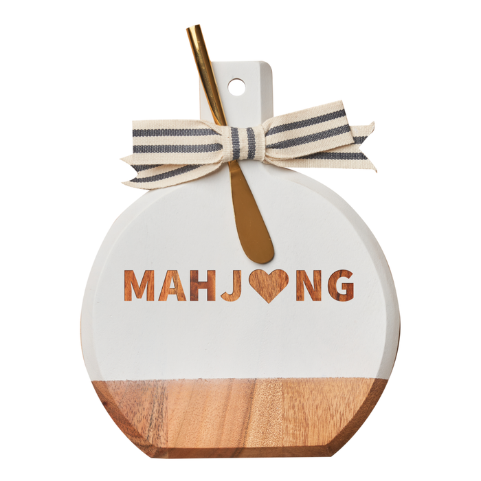 The Maple Acacia Bevel Board in white (9.75 x 8") features a MAHJ♥NG design, a cream ribbon with black stripes, and comes with a gold spreader knife—perfect for serving in style.