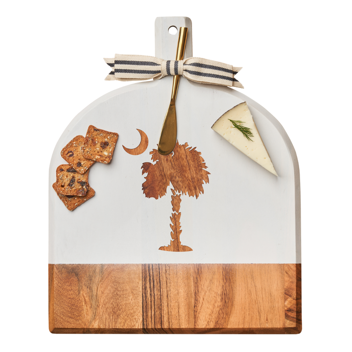 The Maple Acacia Bevel Board White w/ Ribbon & Gold Spreader Knife (15" x 12" x .6") features a palmetto moon design and comes with dill cheese, crackers, and a handle tied with a striped bow.