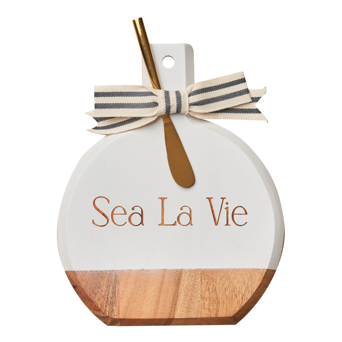 The Maple Acacia Bevel Board White w/ Ribbon & Gold Spreader Knife | Sea La Vie | 9.75 x 8" features a round acacia wood design, white painted top, striped bow, and gold spreader—perfect for stylish charcuterie serving.