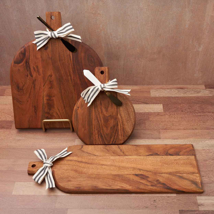 The Maple Acacia Bevel Board with Handle (15 x 12") features a gold ribbon and gray/white spreader, displayed on a wooden surface with a neutral background. Personalization is available.