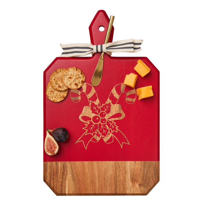 The Maple Acacia Heirloom Board in red features a gold spreader, festive candy cane design, and ribbon—ideal for presenting cheese, crackers, and fruit as a personalized charcuterie board at holiday gatherings. Size: 16 x 10".