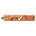 The Maple Acacia Heirloom Board Skinny (34" x 6") features an “Eat Drink & Be Merry” engraving and comes with a gold spreader and ribbon—perfect for an elegant charcuterie display.
