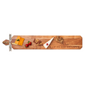 A charcuterie board with cheese, strawberries, nuts, brie, and bread is served on the Maple Acacia Heirloom Board Skinny (34 x 6") engraved with “Eat It Or Starve” and includes a gold spreader and ribbon.