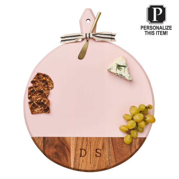 The Maple Acacia Heirloom Board with Handle, Round in Blush (20 x 16"), is shown with a metal cheese knife, crackers, blue cheese, grapes, ribbon bow, and engraved monogram DS. Text reads: Personalize This Item!.