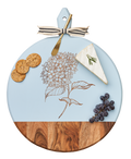 The Maple Acacia Heirloom Board with Handle Round (20 x 16") features a hydrangea design and comes with a gold spreader, tied with a gray & white ribbon—ideal for charcuterie, cheese, crackers, and grapes.