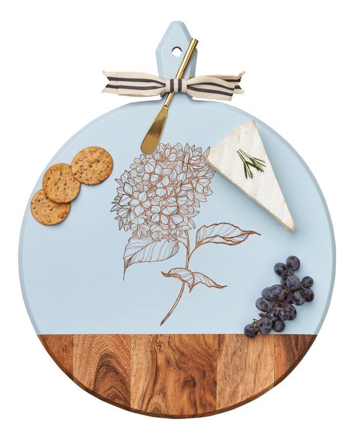 The Maple Acacia Heirloom Board with Handle Round (20 x 16") features a hydrangea design and comes with a gold spreader, tied with a gray & white ribbon—ideal for charcuterie, cheese, crackers, and grapes.