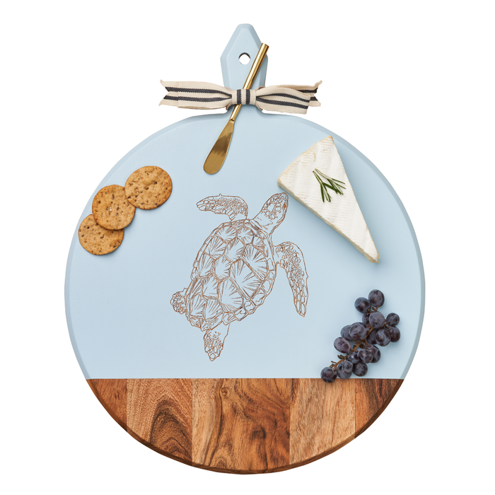 Serve charcuterie on the Maple Acacia Heirloom Board with Handle (round, 20x16") featuring a turtle design; comes with a gold spreader tied with a gray & white ribbon—perfect for cheese, crackers, and grapes.