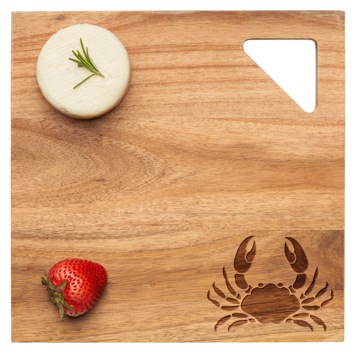 A round white cheese with rosemary and a strawberry rest on Maple’s Acacia Modern Geo Square | Crab | 12 x 12" serving board, featuring crab and triangle cutouts.