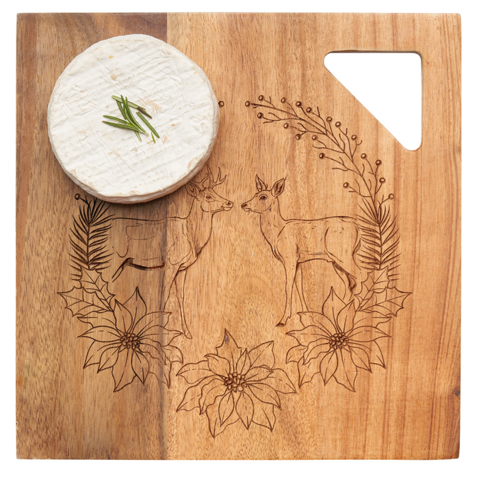 A round wheel of cheese topped with chives sits on the Maple Acacia Modern Geo Square | Deer Wreath 9 x 9" board, engraved with two deer, flowers, and foliage, featuring a triangular cut-out in the corner.