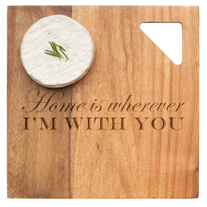 A wheel of chive cheese rests on Maple's Acacia Modern Geo Square charcuterie board (9 x 9"), engraved with "Home Is Wherever I'm With You" and featuring a triangular cut-out in the top right corner.