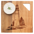A wheel of cheese with chives rests on the Maple Acacia Modern Geo Square board (9 x 9"), engraved with a lighthouse and trees.