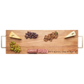 The Maple Acacia Serving Board (30 x 10") with gold handles features "Fucking Delicious" engraved and comes arranged with two cheeses, green and red grapes, crackers, and sliced salami.
