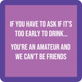 The Drinks On Me Amateur Coaster features a purple border, light purple background, and bold white text: "If you have to ask if it's too early to drink... you're an amateur and we can't be friends." A fun gift or quirky bar cart accessory!.