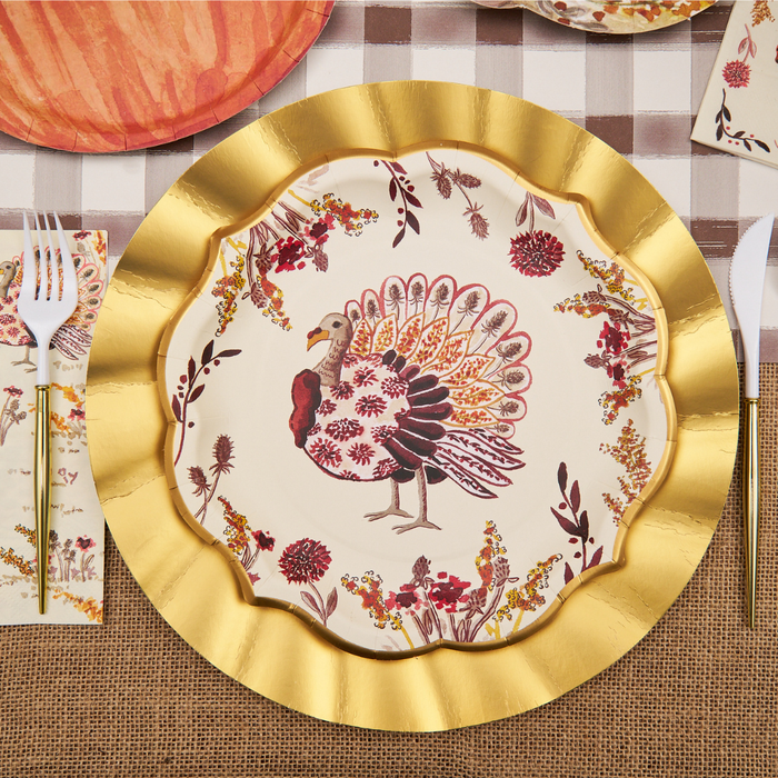 The Sophistiplate Amber Harvest Dinner Plates (8pk) feature a decorative gold scalloped edge and a vibrant turkey illustration surrounded by autumn foliage designs, set against a checkered tablecloth motif with utensils and napkins—making them the perfect festive touch for your Thanksgiving dinner or autumn party table setting.