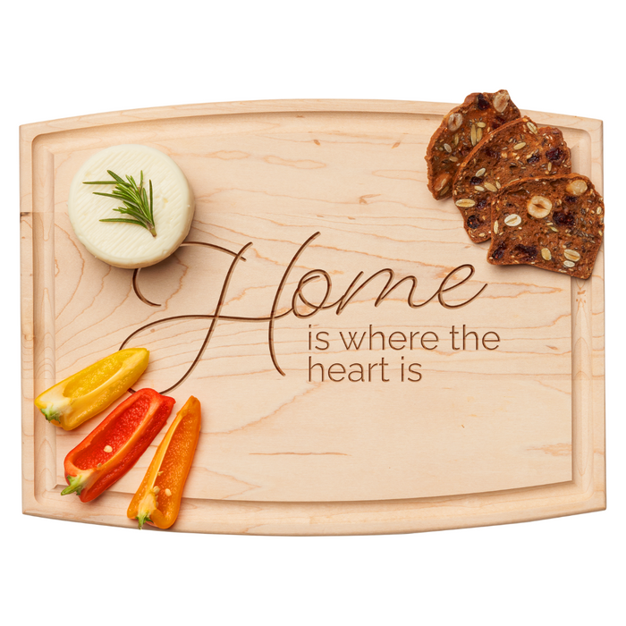 The Maple Arched Artisan Maple Board (12 x 9"), engraved with “Home is where the heart is,” beautifully serves cheese, bell pepper slices, and fruit & nut crisp bread—ideal for any gathering.