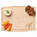 The Maple Arched Artisan Maple Board | Turtle | 12 x 9" features a carved turtle design, shown serving bell pepper slices, rosemary-topped round cheese, and nut and fruit crisps.