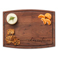 The Maple Arched Artisan Walnut Board (12 x 9") with "Charcuterie" script displays round cheese topped with rosemary, crackers, and peeled orange segments, each arranged neatly in a corner.