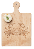A round cheese wheel with dill rests on the Maple Artisan Maple Paddle Board | Crab | 9" x 6", featuring a crab engraving.