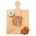 The Maple Artisan Maple Paddle Board (9 x 6") is personalized with KMF initials. It features a round cracker topped with cheese and dill on the top left, and two crispy bread slices on the bottom right.