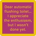 The Drinks On Me Automatic Flush Coaster features yellow text on a purple background with a thick yellow border, reading: "Dear automatic flushing toilet... I appreciate the enthusiasm, but I wasn’t done yet." Perfect for bar cart accessories.