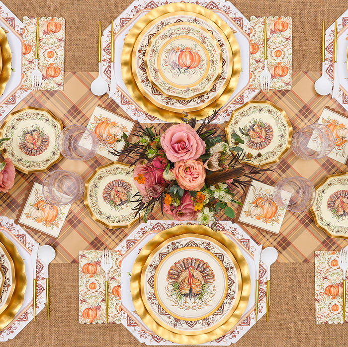 A festive autumn table is set with pumpkin and turkey plates, gold chargers, a floral centerpiece with pink roses, glassware on burlap, and the Hester & Cook Autumn Plaid Runner (20x25") adding seasonal charm.